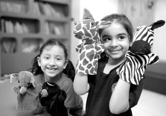 Two girls with giraffe and zebra puppets